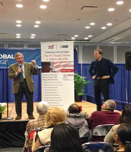 Advisory Board Member Paul W. Bucha (l.) and Veterans Advantage Founder and CEO Scott Higgins (r.) address attendees at the New York Times Travel Show.