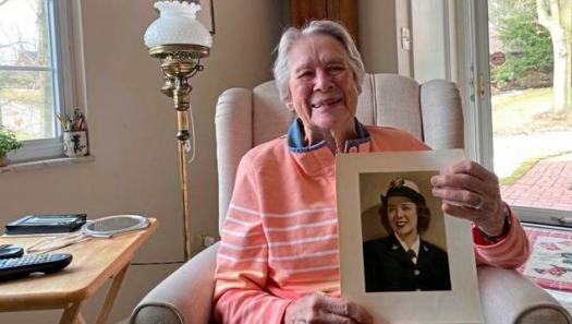 Julia Parsons with a photo of herself from her days of service in the U.S. Navy during World War II